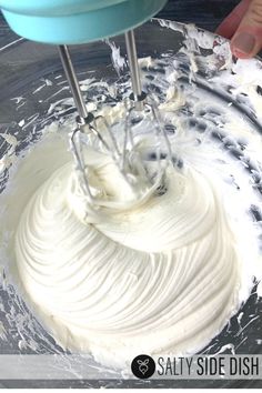 someone mixing white frosting in a bowl