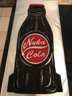 a cake made to look like a coca cola bottle with the word nuka cola on it