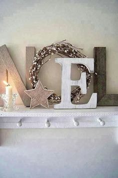 a wooden letter that is sitting on top of a shelf next to a christmas wreath