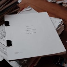 a pile of papers sitting on top of a wooden table