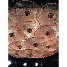 a chandelier made out of pink glass plates hanging from it's ceiling