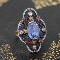 Only one of the prettiest and most special ring we have had the pleasure of owning! The Victorian revival gallery appears to have started its life as a brooch with a shank subsequently added. Really charming details with white enamel and different color gemstones. The sapphire is a stunning medium, almost cornflower blue color - a special no-heat gem! On the finger, it is pretty special. Most def a one of a kind piece. 18kt & 14kt yellow gold Size 6.5 & resizable 4.13ct Sapphire Measures: 10.58 Fine Jewelry Diamond Gemstone Brooches, Luxury Enamel Gemstone Ring For Gift, Elegant Multi-stone Oval Brooch, Elegant Multi-stone Oval Brooches, Elegant Oval Multi-stone Brooches, Oval Jeweled Fine Jewelry, Luxury Sapphire Brooch Jewelry, Fine Jewelry With Jeweled Oval Details, Fine Jewelry With Oval Jeweled Details