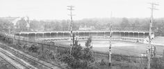 an old black and white photo of a baseball field in the middle of train tracks