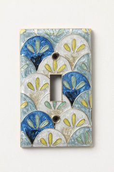 a decorative light switch cover with blue and yellow designs