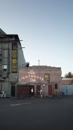 two people standing in front of an old building with graffiti on it's side