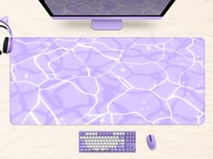 a computer mouse and keyboard sitting on top of a purple mat with water pattern in the middle