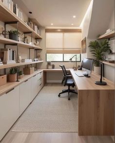 a home office with shelves, desk and computer on the far wall in front of a large window