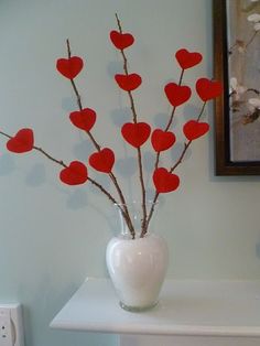 a vase filled with red hearts on top of a white table