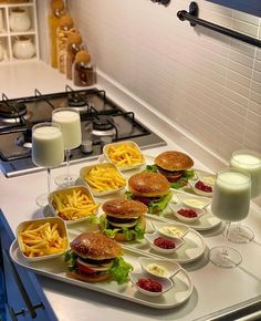 sandwiches and french fries are arranged on a tray in the middle of a kitchen counter