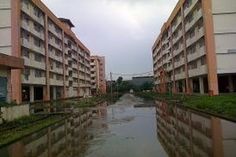 the buildings are reflected in the water on the other side of the river that runs between them