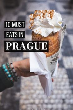 a person holding an ice cream sundae in their hand with the words 10 must eats in prague