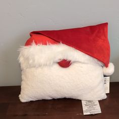 a santa claus hat on top of a pillow with a price tag in front of it