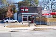 an empty sidewalk in front of a fast food restaurant with red umbrellas on the roof