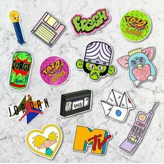 various stickers on a marble surface including an old school cassette, cell phone, and cartoon characters