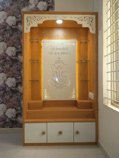 a display case in the corner of a room with floral wallpaper on the walls