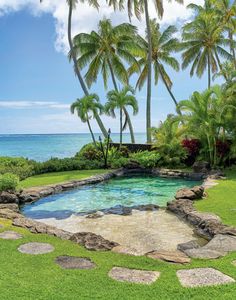 an outdoor swimming pool surrounded by palm trees