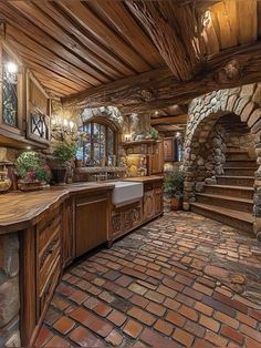 a large kitchen with brick floors and stone walls, along with an arched doorway leading to the second floor