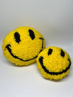 two yellow smiley faces made out of yarn