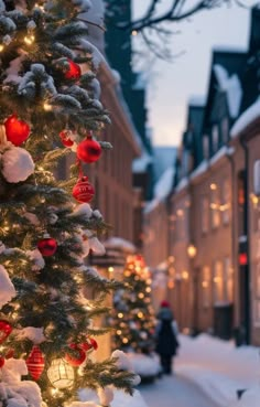 a christmas tree is decorated with red and white ornaments in front of a snowy street