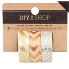 three rolls of washi tape with gold and silver foil on them in front of a cardboard box