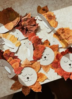 the paper leaves are cut out to look like animals and leaves with faces on them