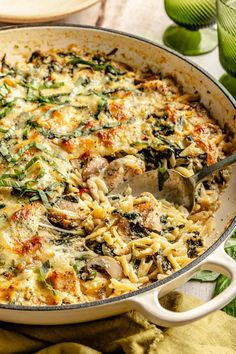 a casserole dish with spinach, mushrooms and cheese in it on a table