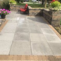 an outdoor patio with seating and flowers in the background