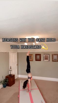 a woman doing a handstand on top of a mat in a living room