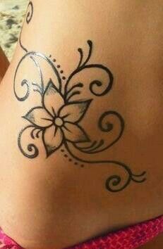 a woman's stomach with a tattoo design on the side of her body,