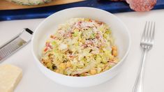 a white bowl filled with coleslaw and garnished with parmesan cheese