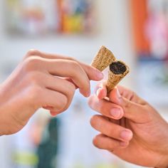 two people are exchanging something with each other in the middle of their hands, one is holding a piece of cork