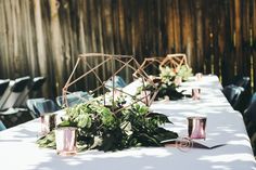 the table is set up with candles and greenery for an outdoor wedding reception or special event