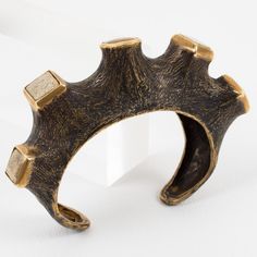 This is part of Chairish’s Costume Jewelry assortment.  This stunning sculptural brutalist bronze cuff bracelet was hand-crafted by a French artist in the 1980s. This is a one-of-a-kind piece with organic inspiration. The bangle features a carved and textured tree branch with an original brown patina, topped with cabochons in travertine stone and genuine amber. There is no visible maker's mark. We have had this piece in our collection for nearly thirty years, and we have never seen anything like Unique Brass Cuff Jewelry, Unique Brass Cuff Bracelet For Formal Occasions, Unique Bronze Cuff Bracelet For Formal Occasions, Unique Metal Cuff Bracelet With Oxidized Finish, Unique Oxidized Metal Cuff Bracelet, Bronze Hand Forged Metal Cuff Bracelet, Hand Forged Bronze Metal Cuff Bracelet, Modernist Metal Cuff Bangle, Hand Cast Bronze Metal Cuff Bracelet