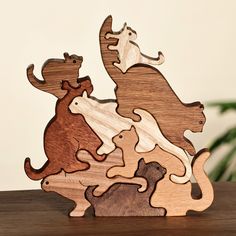 a wooden puzzle with animals on it sitting on a table next to a potted plant