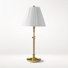 a gold lamp with a white shade on it's base and a white lampshade