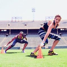 two women doing push ups in front of an empty stadium