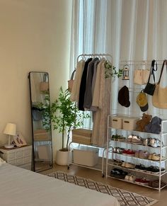 a bedroom with a bed, mirror and clothes rack