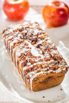 a close up of a piece of bread on a plate with apples in the background