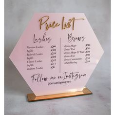 a pink and gold wedding table plan on a wooden stand with the names of the bride and groom