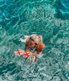 a woman in the water holding a starfish