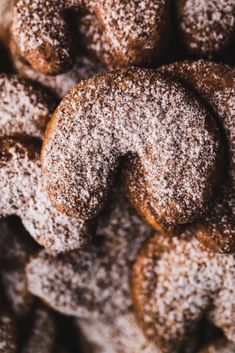 powdered sugar covered donuts piled on top of each other in a pile together