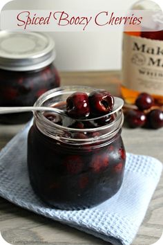 a jar filled with cherries sitting on top of a table