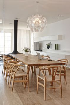 a dining room table with chairs and a laptop on it