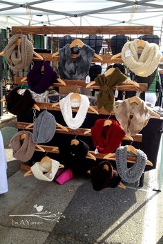 hats and scarves are on display at an outdoor market