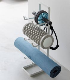 a blue yoga mat sitting on top of a white stand next to a black and gray object