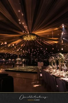 an image of a banquet hall setting with lights and flowers on the tables in front of it