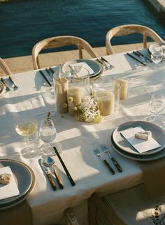 the table is set with silverware and place settings