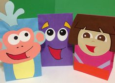 three children's paper bags with faces on them