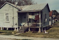 an old run down house with clothes hanging out to dry on the front and side