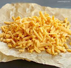 a pile of cheesy bread sitting on top of a piece of wax paper